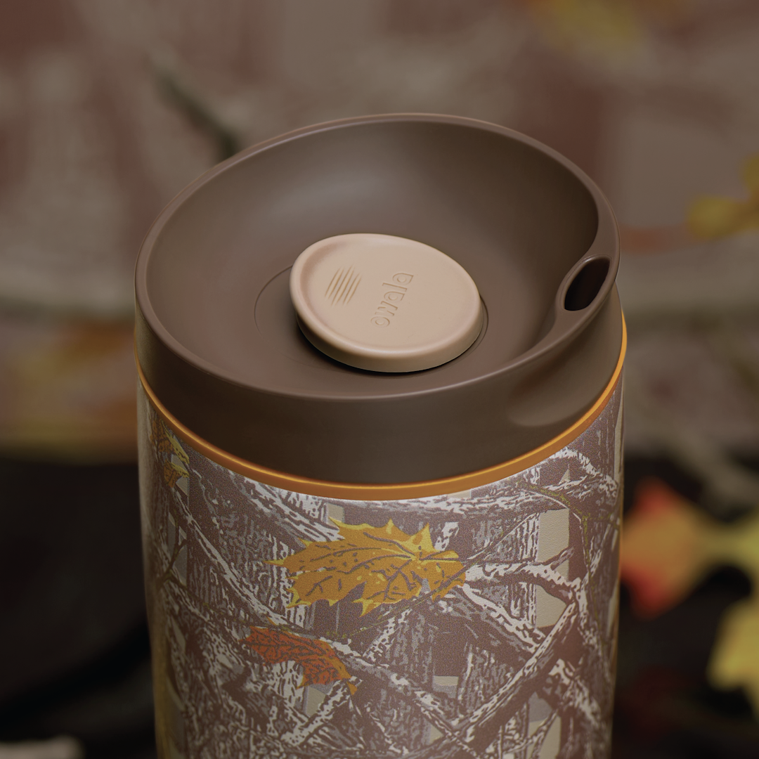 Owala FreeSip Sway in Out of Sight, lid detail showing brown flip cap with cream push-button and orange accent over woodland camo patterned body